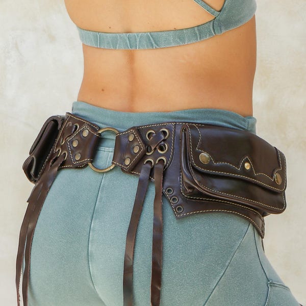 May include: A brown leather belt with multiple pockets and fringe details. The belt has a metal buckle and is worn over a pair of light blue pants.
