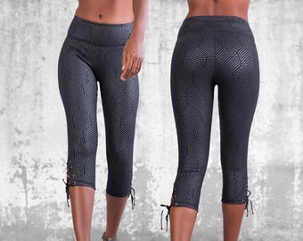 May include: Black capri leggings with a geometric pattern and lace-up detailing at the sides.