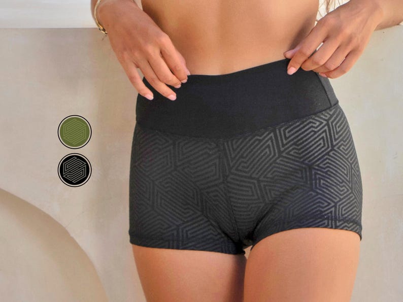 May include: Black athletic shorts with a geometric pattern. The shorts have a wide waistband and a form-fitting design. The geometric pattern is a darker shade of black, creating a subtle contrast. The shorts are designed for athletic activities.