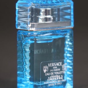 Puede incluir: Una taza de cer&aacute;mica blanca con un asa negra y el texto "But First, Coffee" en negrita negra. La taza se encuentra sobre un fondo borroso, sugiriendo un ambiente acogedor.