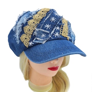 Puede incluir: Gorra vaquera azul con visera, adornada con parches de encaje dorado y estrellas blancas bordadas. La gorra tiene un diseño deshilachado, que ofrece una estética única y artesanal.