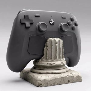 May include: A dark grey video game controller featuring a central Steam logo, dual analogue sticks, a directional pad, and four action buttons, resting on a weathered, light grey stone column base with a square plinth and a fluted cylindrical top.