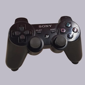 Könnte beinhalten: Ein schwarzer Sony PlayStation 3 Wireless-Controller mit den Tasten "Start", "Select" und "PS".