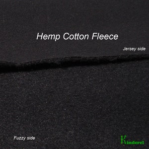 May include: A close-up of black Hemp Cotton Fleece fabric. The top section shows the Jersey side, while the bottom displays the Fuzzy side. The fabric is a deep black colour, with a textured appearance on both sides.