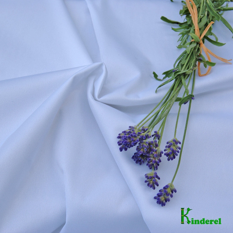 May include: A light blue fabric with a bunch of lavender flowers on top. The fabric is smooth and has a slight sheen. The flowers are purple and have a delicate fragrance. The fabric is perfect for sewing projects, such as clothing, bedding, and home decor.