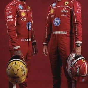 May include: Two individuals in red racing suits, each holding a helmet. One helmet is yellow with a black design, the other is red with white accents. The suits feature sponsor logos and the HP logo.