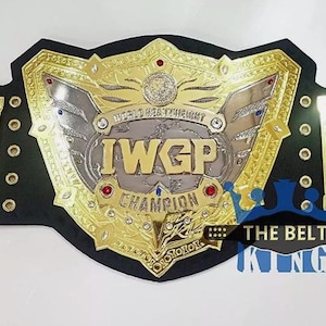 以下が含まれることがあります： 黒い革のストラップが付いた、金と銀のIWGPチャンピオンレスリングベルト。 ベルトには、「IWGP CHAMPION」の文字や地球のデザインなど、複雑なディテールが施されています。 ベルトは赤と青の宝石で飾られています。