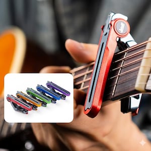 May include: A red and silver guitar capo is clamped onto the strings of an acoustic guitar. The capo has a black grip and a circular logo. A smaller image shows five additional capos in red, orange, green, blue, and purple.