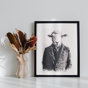 Può includere: Illustrazione in bianco e nero di una pecora con un vestito, incorniciata in una cornice nera. L'illustrazione è su sfondo bianco. Un vaso con fiori secchi è in primo piano.