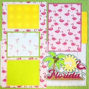 May include: A scrapbook page with a Florida theme. It features a pink flamingo pattern, yellow sunburst and green palm tree accents. The text "Welcome to Florida" and "having fun in the sun" are included.