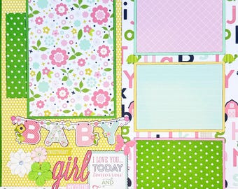 Könnte beinhalten: Eine Scrapbook-Seite mit Blumenmuster, einem grünen Punktemuster-Feld und drei rechteckigen Fotorahmen. Die Seite enthält den Text BABY, girl, I LOVE YOU... TODAY tomorrow AND FOREVER und dream come true sowie dekorative Papierblumen und einen Schmetterling.