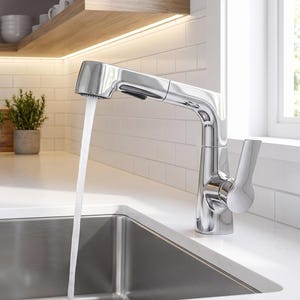 Può includere: Un rubinetto da cucina in cromo lucido con doccetta estraibile e una singola leva laterale, che eroga un flusso costante d'acqua in un lavello rettangolare in acciaio inossidabile incassato in un piano di lavoro bianco.