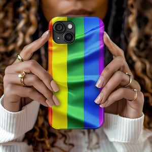 May include: A phone case with a rainbow flag design. The case is made of a soft, flexible material and has a raised lip to protect the screen.