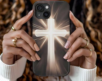 May include: A white cross with a glowing light behind it. The cross is on a black phone case with a white border.