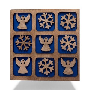 May include: Wooden Tic-Tac-Toe board with a blue background and nine squares. The squares contain alternating angel and snowflake designs. The board is made of light brown wood and is a decorative game.