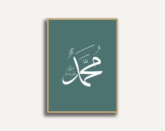 Könnte beinhalten: Gerahmter tealfarbener Druck mit weißer arabischer Kalligraphie. Das Kunstwerk zeigt den Namen "Muhammad" in eleganter Schrift. Der Rahmen ist hellbraun und der Hintergrund ist einfarbig teal.