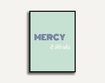 Könnte beinhalten: Ein gerahmter Druck mit hellgrünem Hintergrund. Das Wort "MERCY" steht in blauem, stilisiertem Text, und die Worte "It Works" stehen in weißer, kursiver Schrift. Der Rahmen ist schwarz.