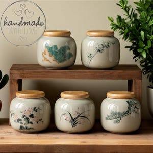 Tetera de cerámica con orquídea pintada a mano y recipiente sellado para té: portátil, resistente a la humedad y con diseño retro para amantes del té.
