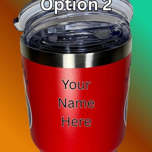 Puede incluir: Un vaso t&eacute;rmico rojo con tapa transparente y borde negro. El texto "Option 2" est&aacute; impreso en la tapa. Las palabras "Your Name Here" est&aacute;n impresas en negro sobre la superficie roja del vaso.