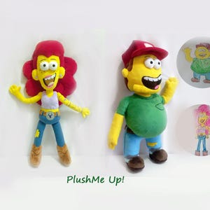 May include: Two plush toys of cartoon characters, one with red hair and the other with a red cap. The dolls are yellow with blue trousers and brown shoes. Two cartoon drawings are in the background. The text "PlushMe Up!" is at the bottom.