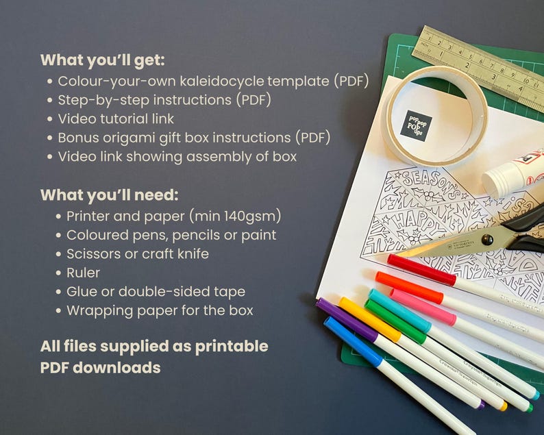 May include: A printable PDF craft kit featuring a black and white line art kaleidocycle template with holiday motifs, a metal ruler, a roll of tape, a glue stick, scissors, and a set of colorful markers on a green cutting mat with text instructions.