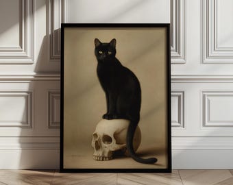 May include: A framed print featuring a black cat perched atop a human skull. The cat has yellow eyes and a sleek black coat. The skull is white, and the background is a neutral beige. The print is in a black frame.