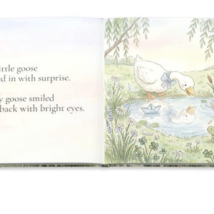 May include: An open book with a watercolor illustration of a goose looking into a pond. The text reads, "The little goose peeked in with surprise. A silly goose smiled right back with bright eyes."