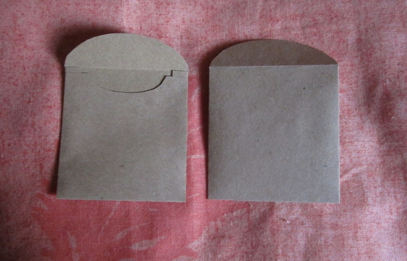 May include: Two brown paper envelopes with rounded tops. The envelopes are blank and have a flap on the top.