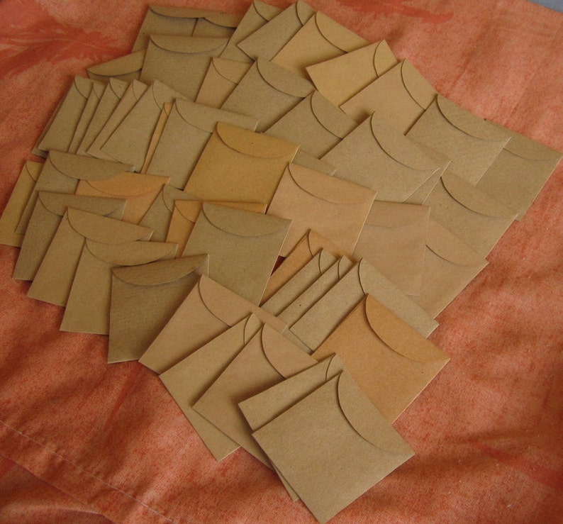 May include: A large pile of brown paper envelopes with a flap on the top. The envelopes are arranged in a random pattern.