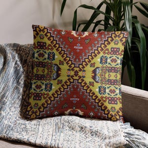 May include: A square throw pillow featuring a vibrant, symmetrical pattern in shades of deep red, lime green, and dark blue. The design consists of intricate geometric shapes and ornate borders that create a bold, multi-colored visual effect.