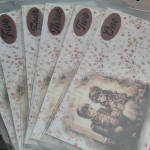 May include: A collection of six decorative cards, each with a unique design. The cards feature a vintage illustration of two figures and are adorned with brown oval stickers labeled with numbers. The background has a speckled pattern.