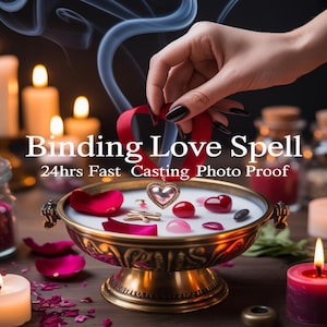 Pode incluir: Um pingente em forma de coração com uma moldura prateada e um centro rosa é colocado em uma tigela com objetos vermelhos e rosa. O texto "Binding Love Spell" é exibido acima da tigela. Velas acesas e pétalas de rosa circundam a tigela.
