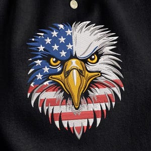 May include: Black sweatshirt featuring an embroidered eagle head design. The eagle's head is split, with the left side displaying blue stars on a white background and the right side showing white feathers. The beak is yellow, and the bottom has red and white stripes.