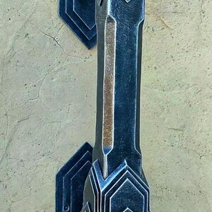 Peut inclure: Une poignée de porte en métal noir avec un design art déco. La poignée est montée sur un mur et a une base carrée avec un dessus décoratif.