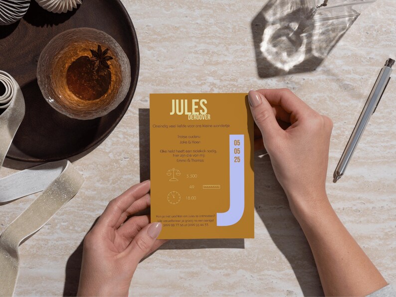 May include: A yellow card with the text "Jules Deroover" in black. The card has a blue "J" on the right side and the date "06 06 25" on the right side. The card also has a scale and a clock with the text "1.000" and "1.662" on the card.