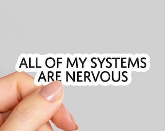 May include: A white sticker with black text that reads "ALL OF MY SYSTEMS ARE NERVOUS." The sticker is held by a hand with a light gray background.