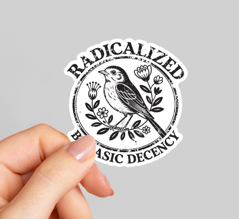 Op de afbeelding: Een witte sticker met een zwart-wit illustratie van een vogel op een tak, omringd door bloemen. De sticker bevat de woorden "RADICALIZED" en "BASIC DECENCY" in een cirkelvormig ontwerp.
