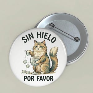 Könnte beinhalten: Ein runder Button mit einer Cartoon-Katzen-Illustration. Die Katze mit braunem und beigem Fell hält ein Weinglas mit Eiswürfeln. Der Text "SIN HIELO POR FAVOR" ist auf dem Button aufgedruckt.