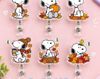 Puede incluir: Seis portatarjetas de acrílico con Snoopy en varias escenas otoñales con hojas, calabazas y café. Cada uno está numerado del uno al seis. El texto inferior dice Buy 5 Get 1 Free. Los diseños incluyen a Snoopy con bufanda, sosteniendo una calabaza, sentado entre hojas, con gorro, sobre un tronco de árbol y con Woodstock.