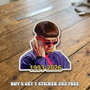 May include: A die-cut sticker featuring a person with a brown bowl cut hairstyle wearing red-rimmed sunglasses and a purple jacket with a yellow collar. The text 1993-2026 is printed in yellow at the bottom. The sticker measures 2x2 inches.