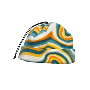 May include: A white fleece neck gaiter with a wavy pattern in teal and orange.