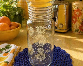 Jarra de zumo Pyrex de estilo vintage con tapa amarilla a juego.