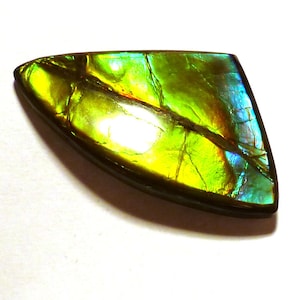 May include: A green, iridescent gemstone with a teardrop shape and a natural crack running through it.