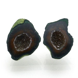 May include: Two green and brown geode halves with a crystal interior. The geodes are irregularly shaped and have a rough texture.