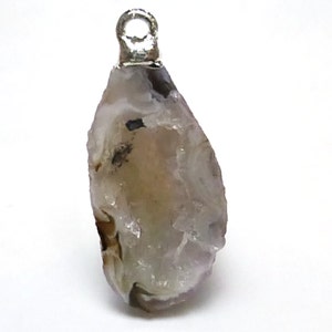 May include: A raw, white and grey agate pendant with a silver bail. The agate has a natural, rough texture and a translucent appearance.