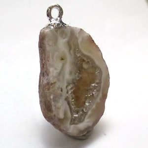 May include: A brown and white agate pendant with a silver bail. The agate has a natural crystal formation with a clear center and brown edges.