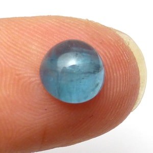 K&ouml;nnte beinhalten: Ein runder, hellblauer Edelstein mit einer glatten, polierten Oberfl&auml;che.