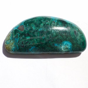 May include: A smooth, polished green and blue gemstone with a unique pattern. The gemstone is oval shaped and has a glossy finish.