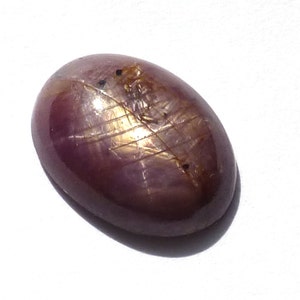 May include: A pink and gold oval-shaped gemstone with a star-like pattern.
