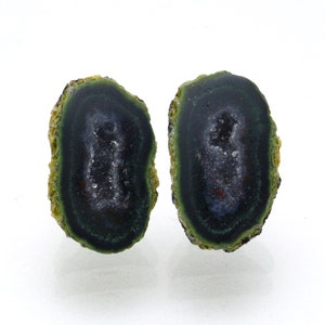 May include: A pair of green and black agate slices with a crystal center. The slices are smooth and polished, with a natural, irregular shape.